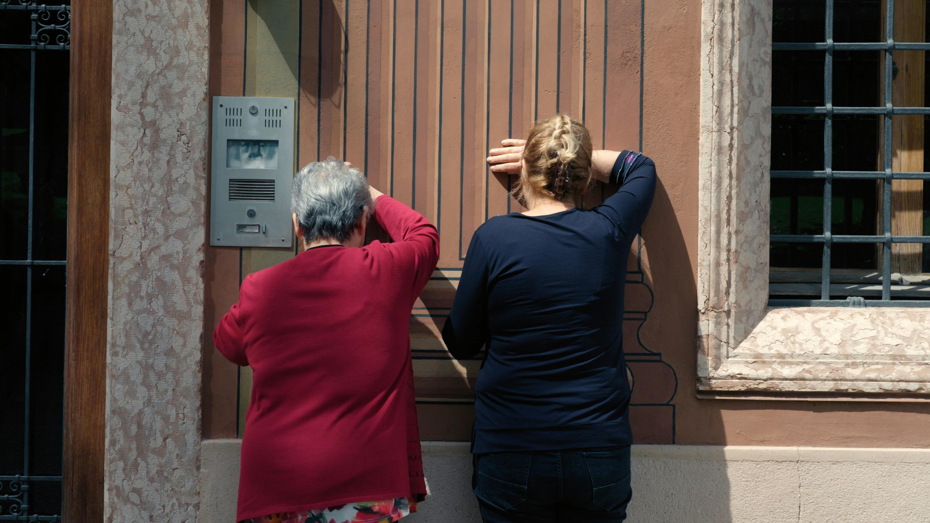 Dal film Un, due, tre...stella! diretto da Emanuele Gerosa e prodotto da Oneworld DocuMakers e Jump Cut Due signore di schiena sono appoggiate a un muro con il braccio destro sollevato a coprire gli occhi