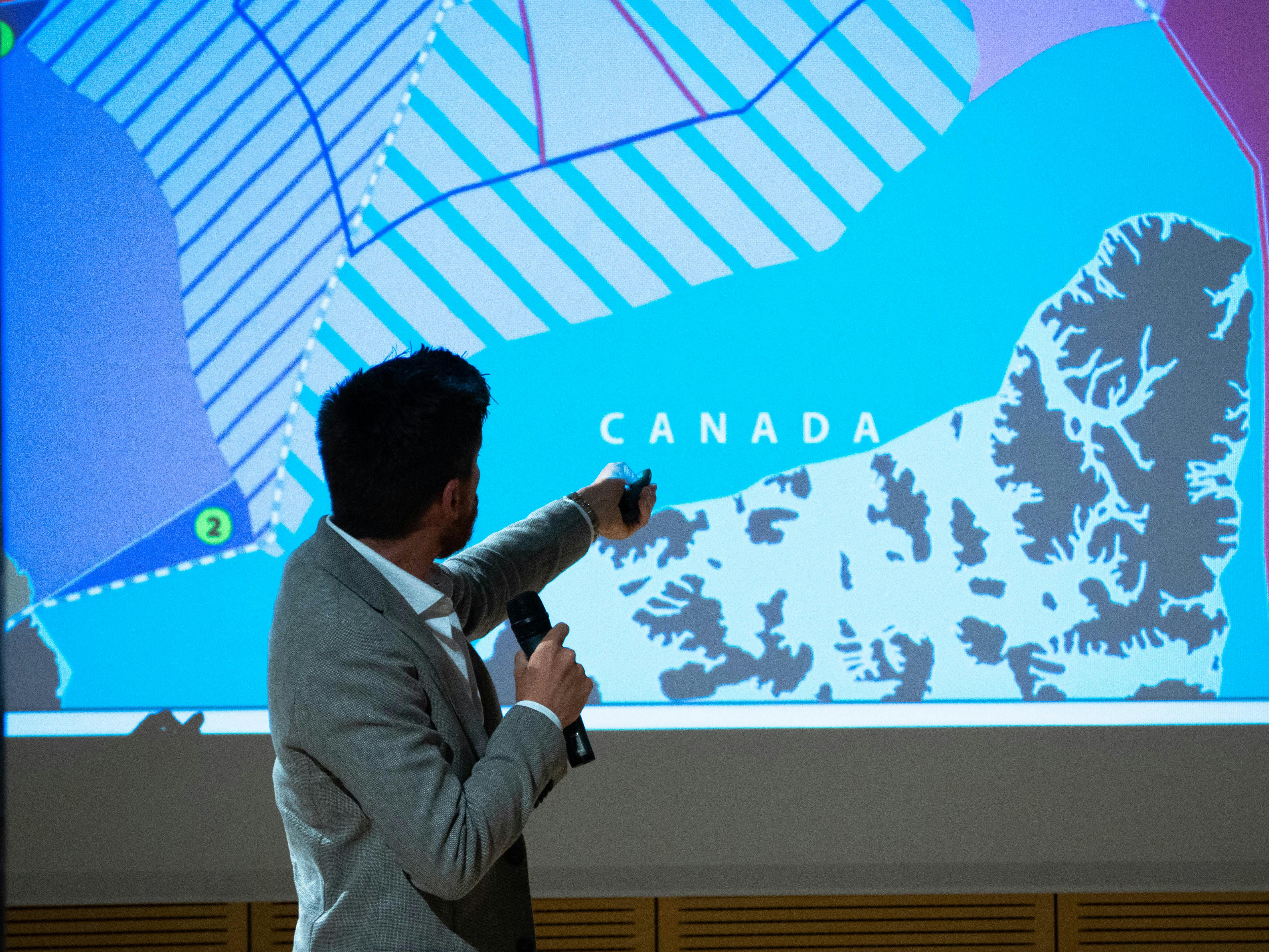 In the photo, Federico Petroni, editorial advisor for Limes, has his back to the camera and is pointing to a slide behind him. He is holding a microphone in his hand.