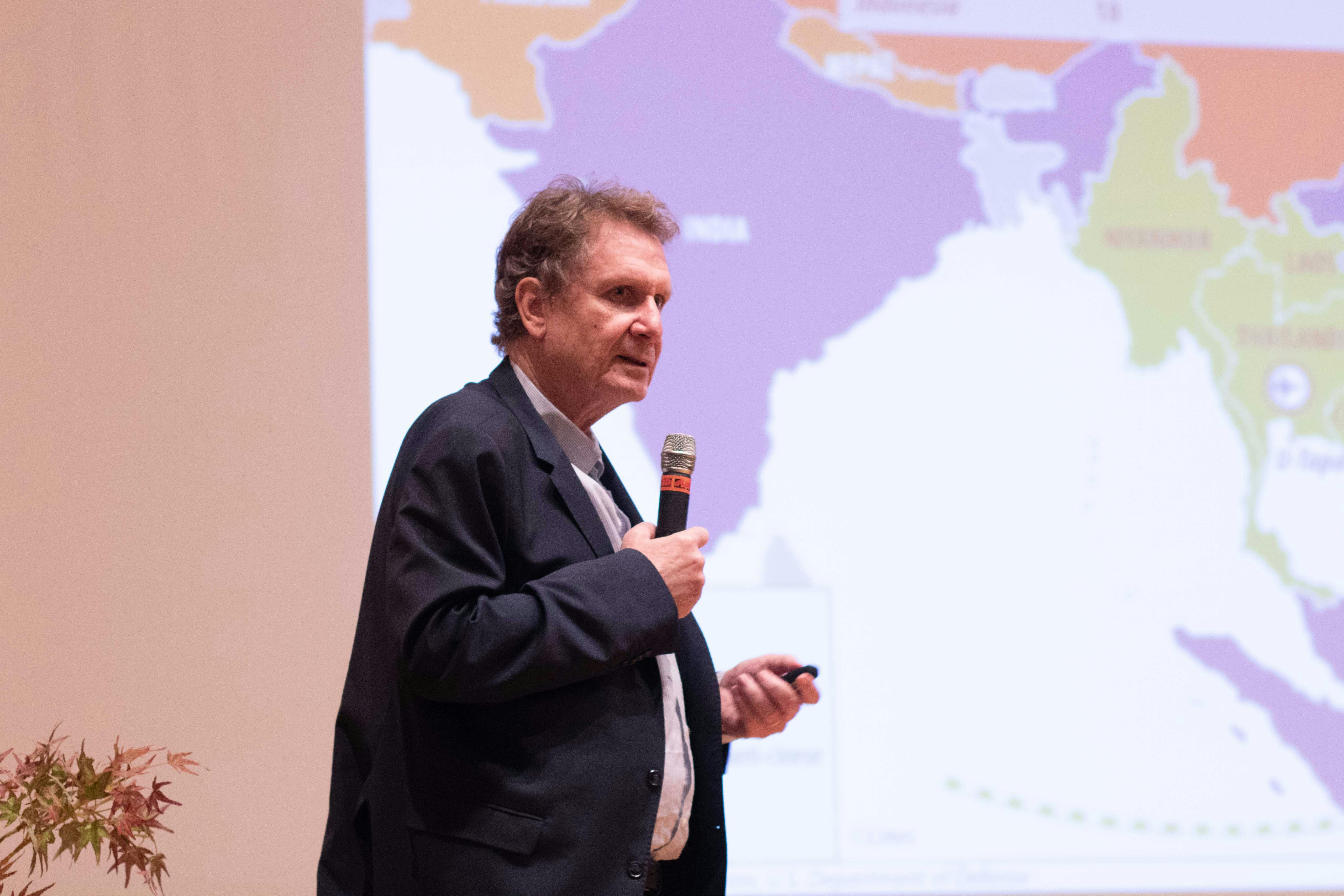 In the photo, Lucio Caracciolo, director of Limes, is speaking into a microphone while standing. Behind him, a map is projected.
