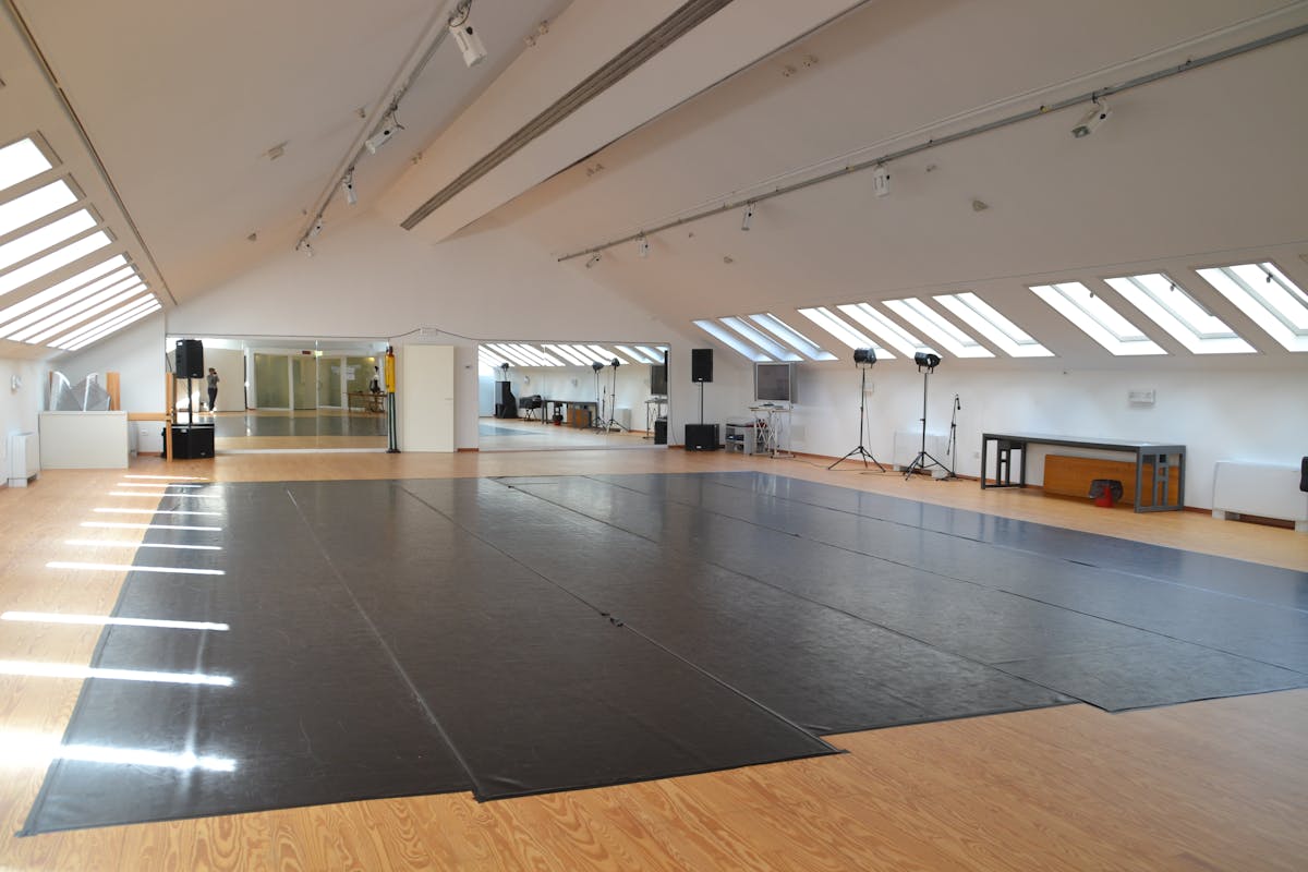 Sala al secondo piano dello Studio con tappeto danza nero e materiale tecnico