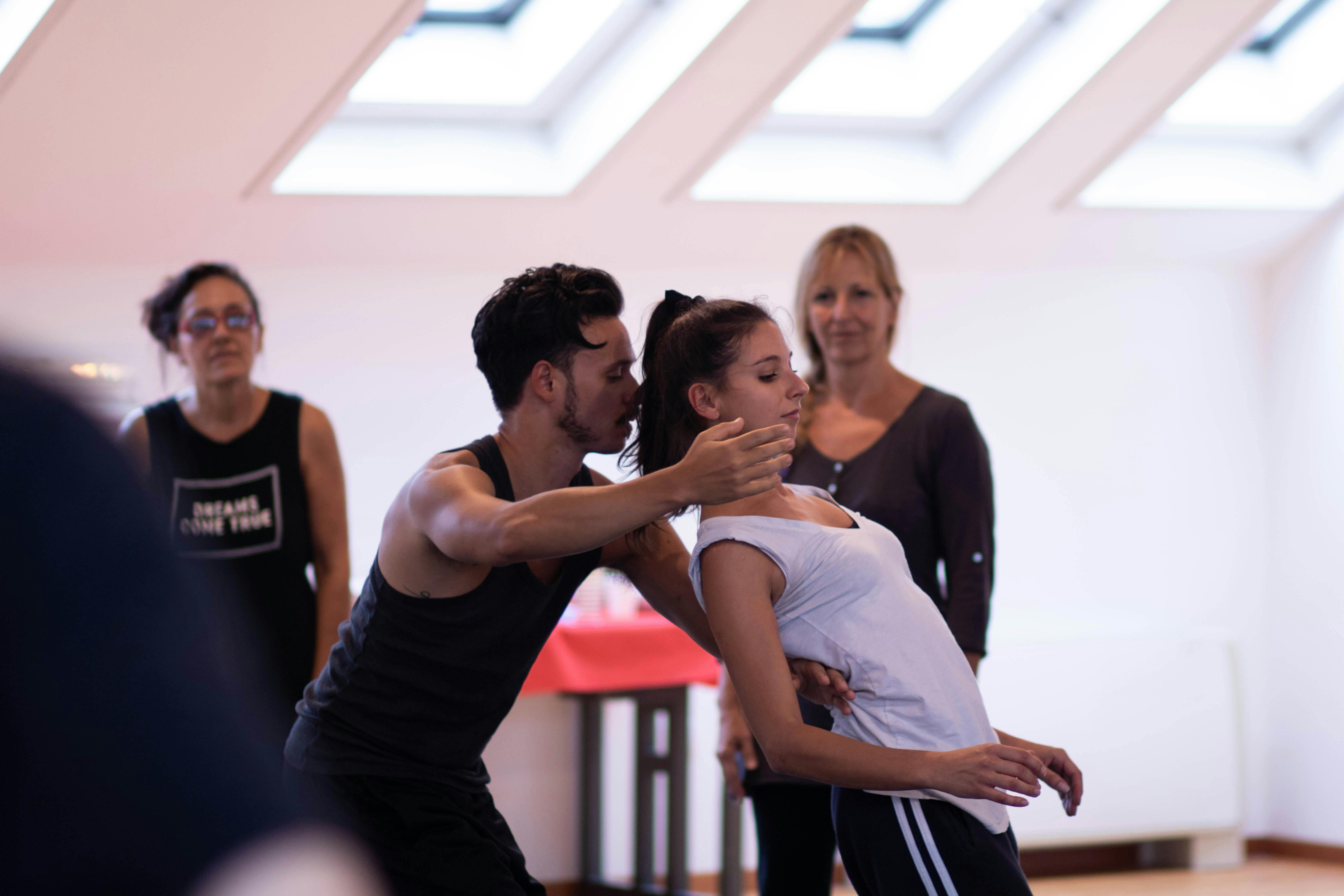 Performers in a dance studio rehearse choreography