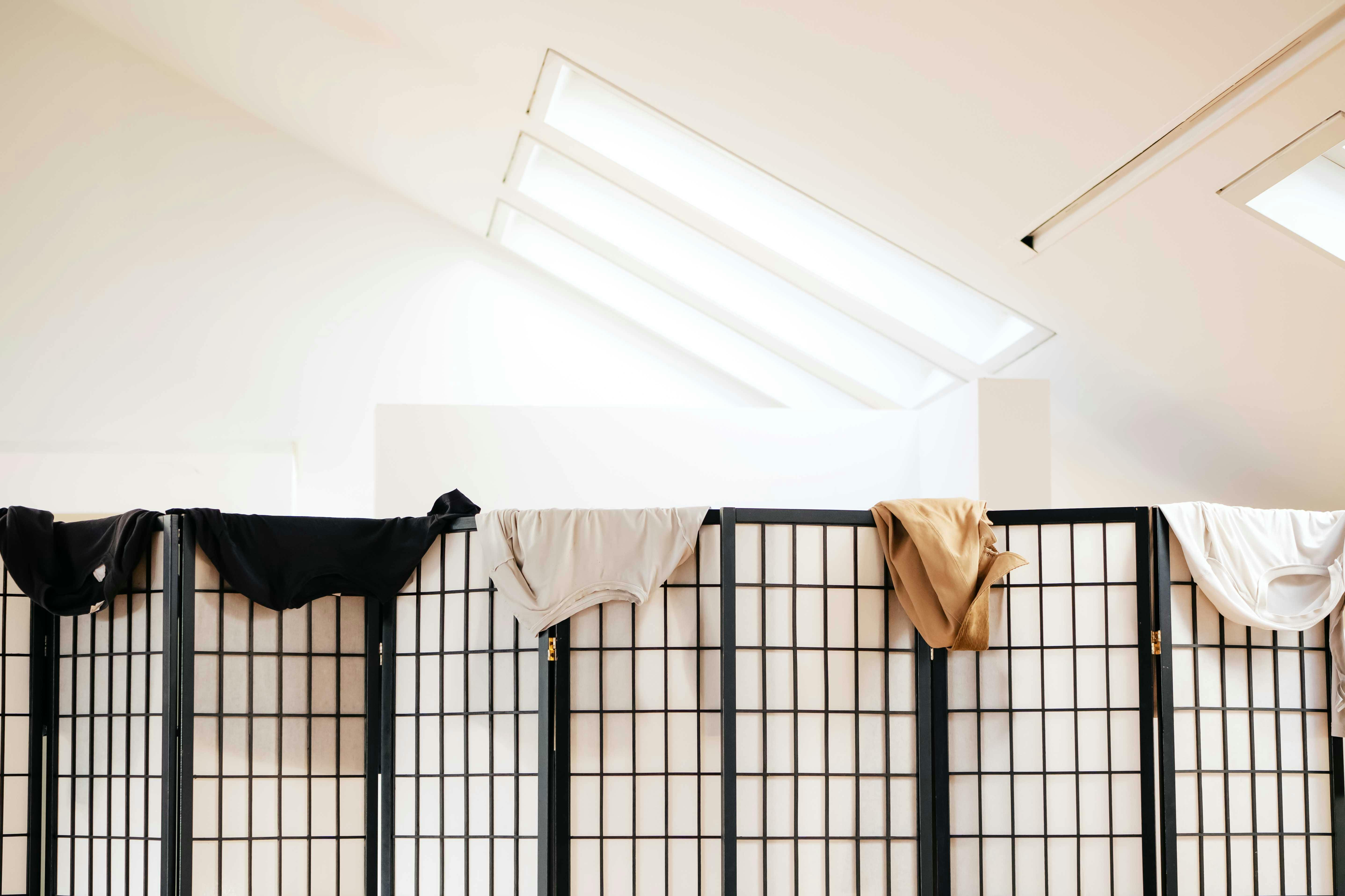 Paravento nero e bianco con appoggiati sopra vestiti