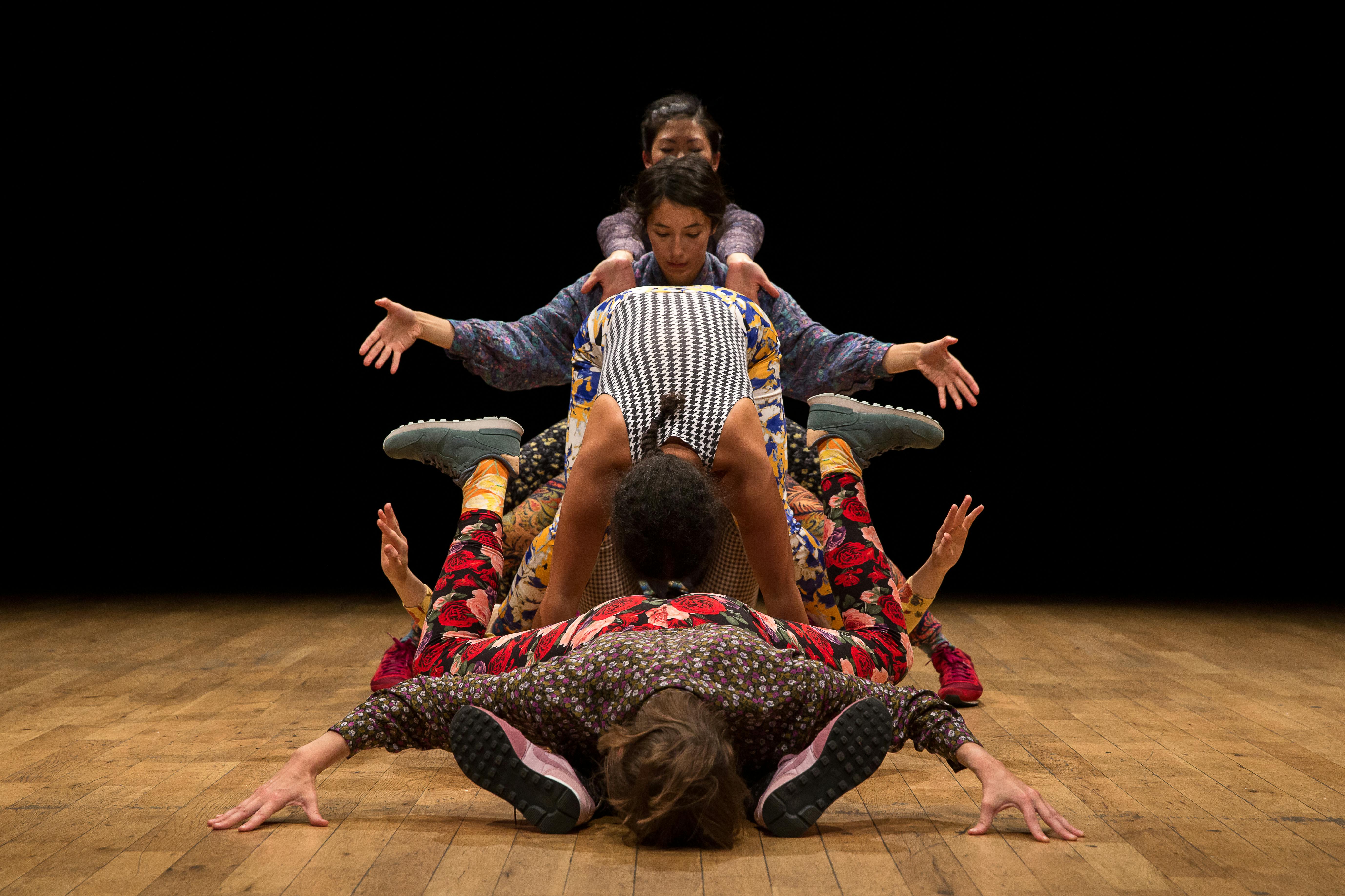 Performers fit their bodies together to create shapes that can seem like an alien being. They wear colorful and patterned clothes