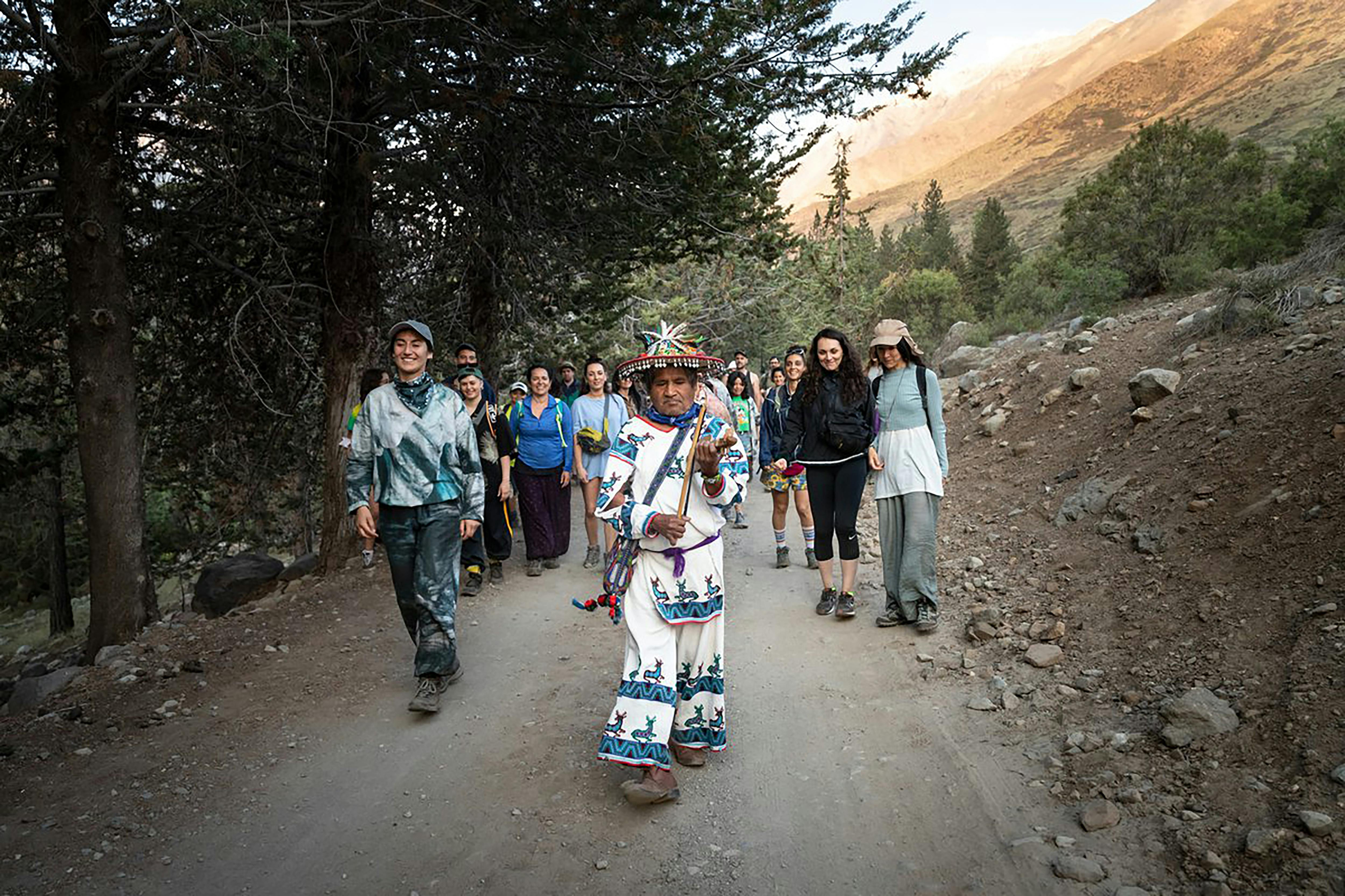 Un gruppo di persone cammina nella natura guidate dallo sciamano Huichol Juan José Ramirez Katira