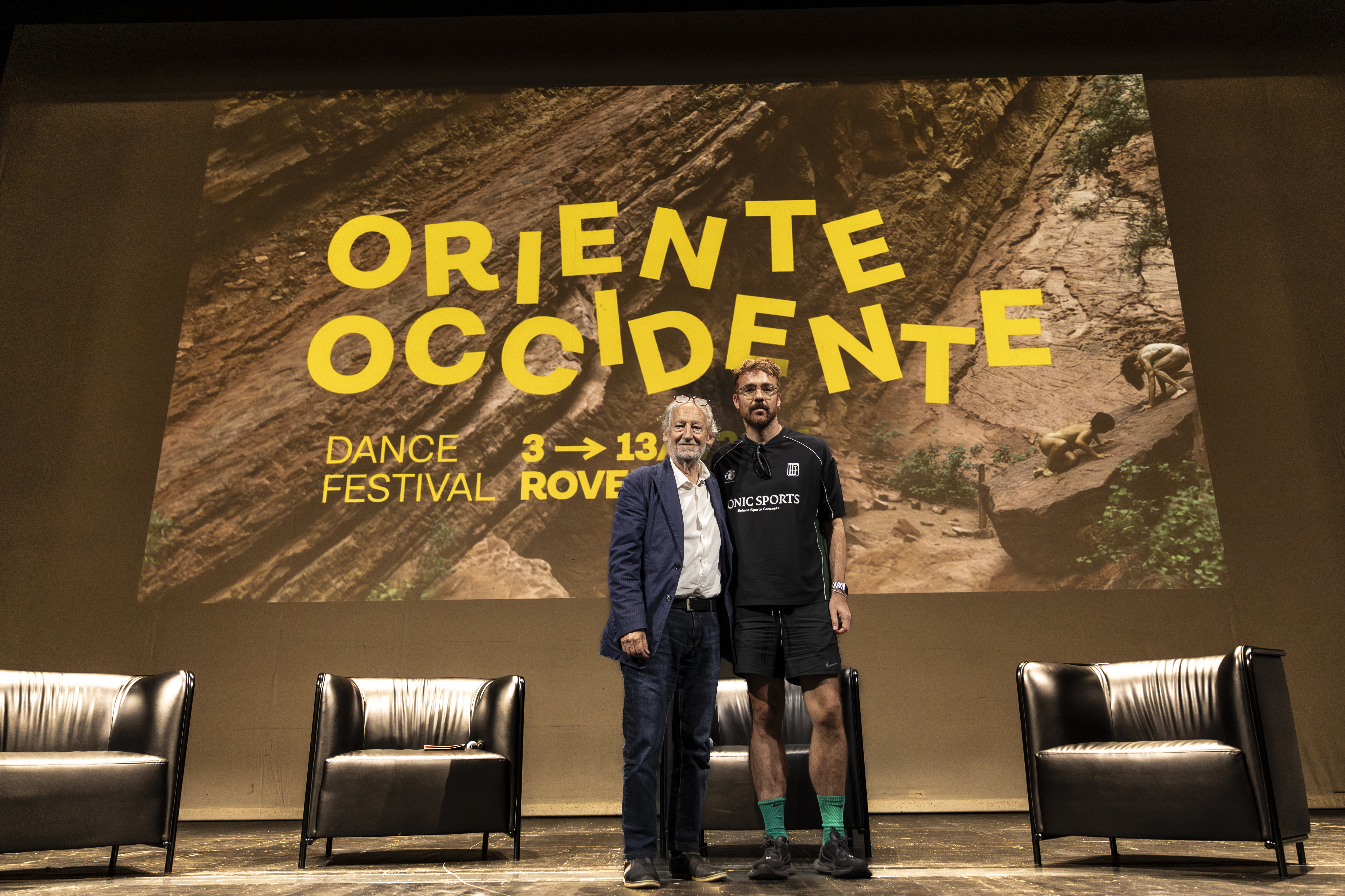 Marcos Morau and Lanfranco Cis, with the image of the 45th Oriente Occidente Dance Festival in the background