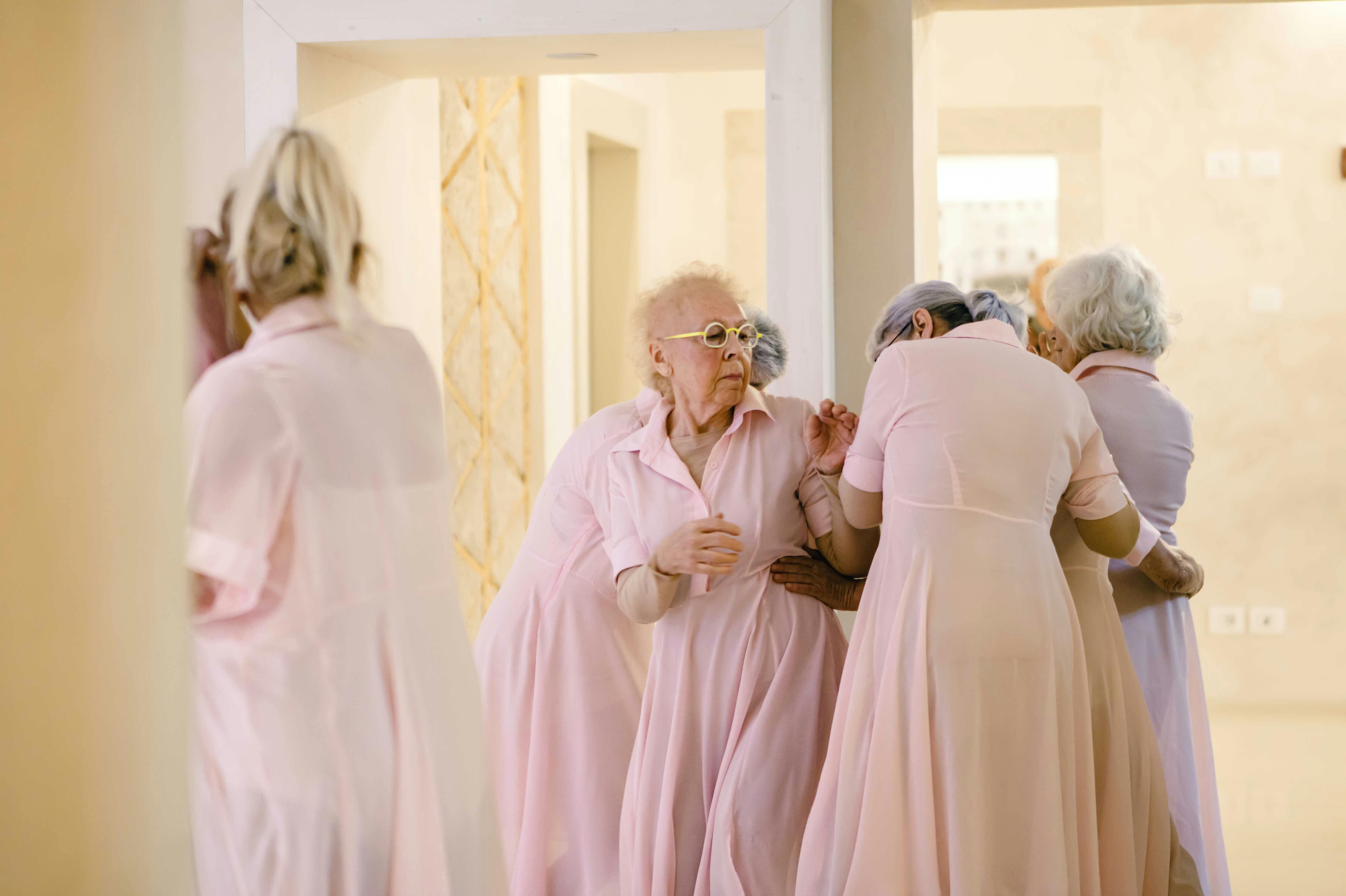 Un gruppo di donne over 70, partecipanti al laboratorio Deja vu,  con indosso un vestito rosa