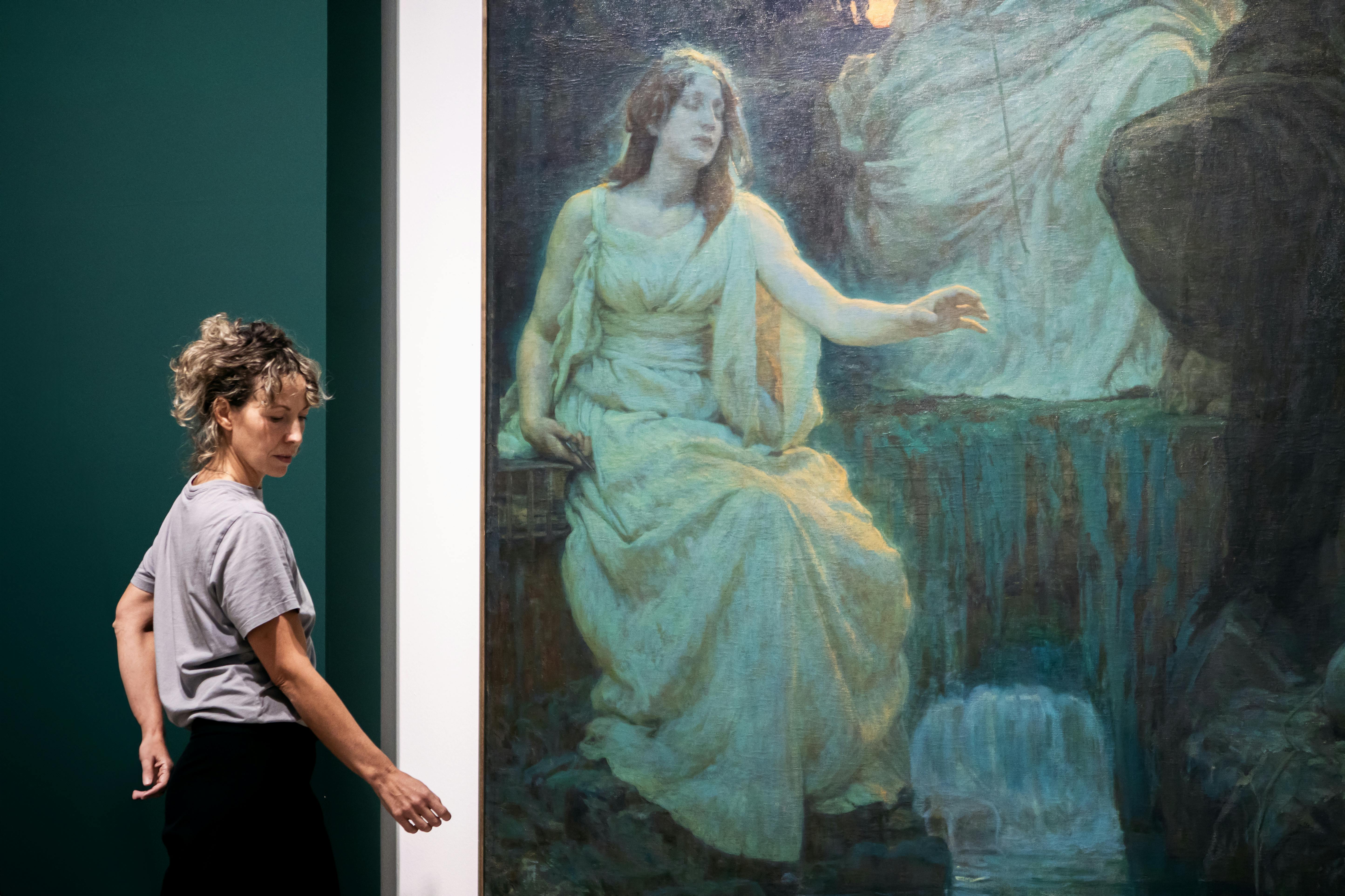 La performer e autrice Claudia Catarzi in una posa che imita il dipinto alle sue spalle