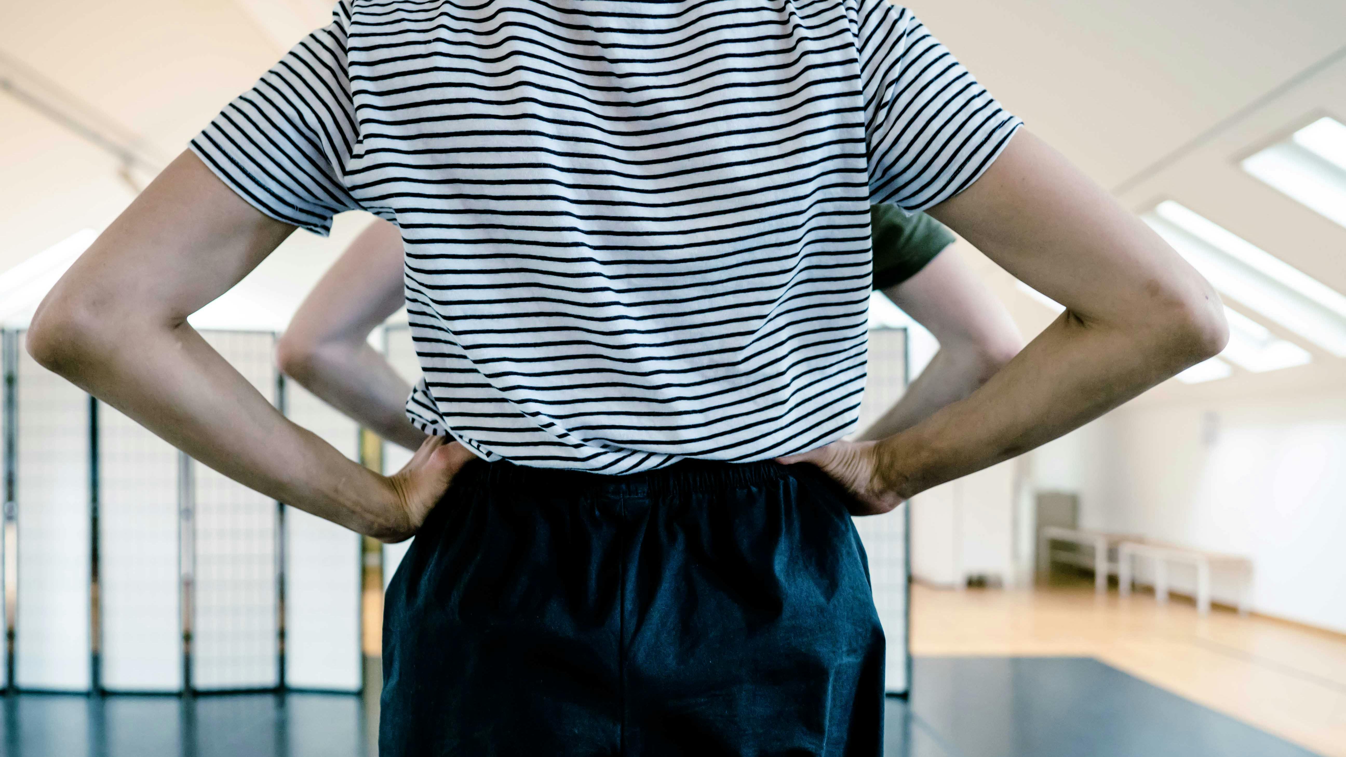 Residenza artistica | ph Giulia Lenzi Due persone una dietro l'altra di schiena con le mani sui fianchi