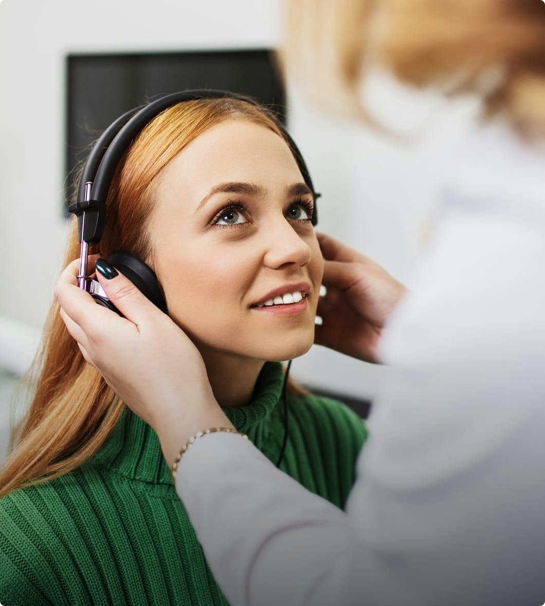 a woman wearing headphones wearing a green turtle neck