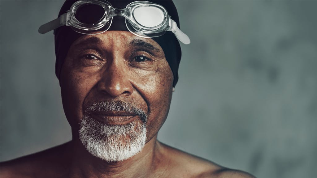 Man wearing swimmer's cap and goggles.