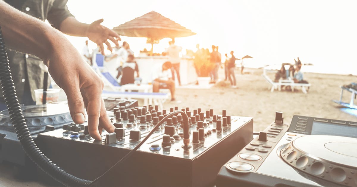 a close up of someone on a dj set on the beach