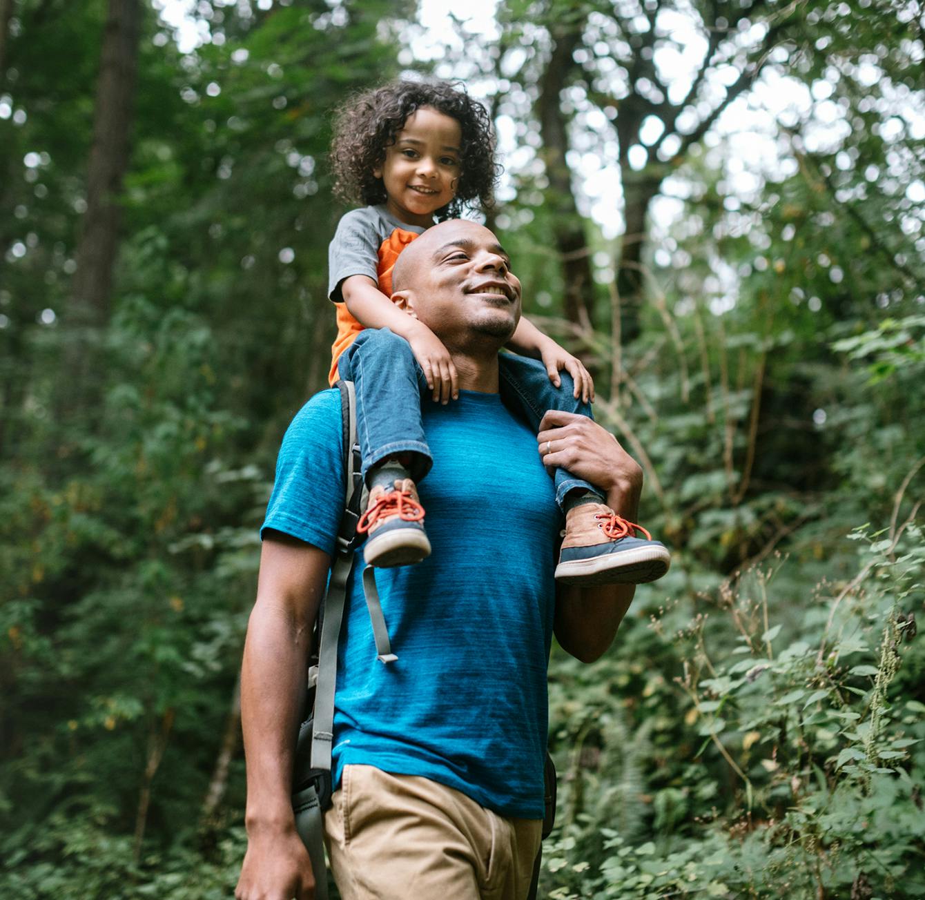 dad carrying his child on his shoulders while hiking