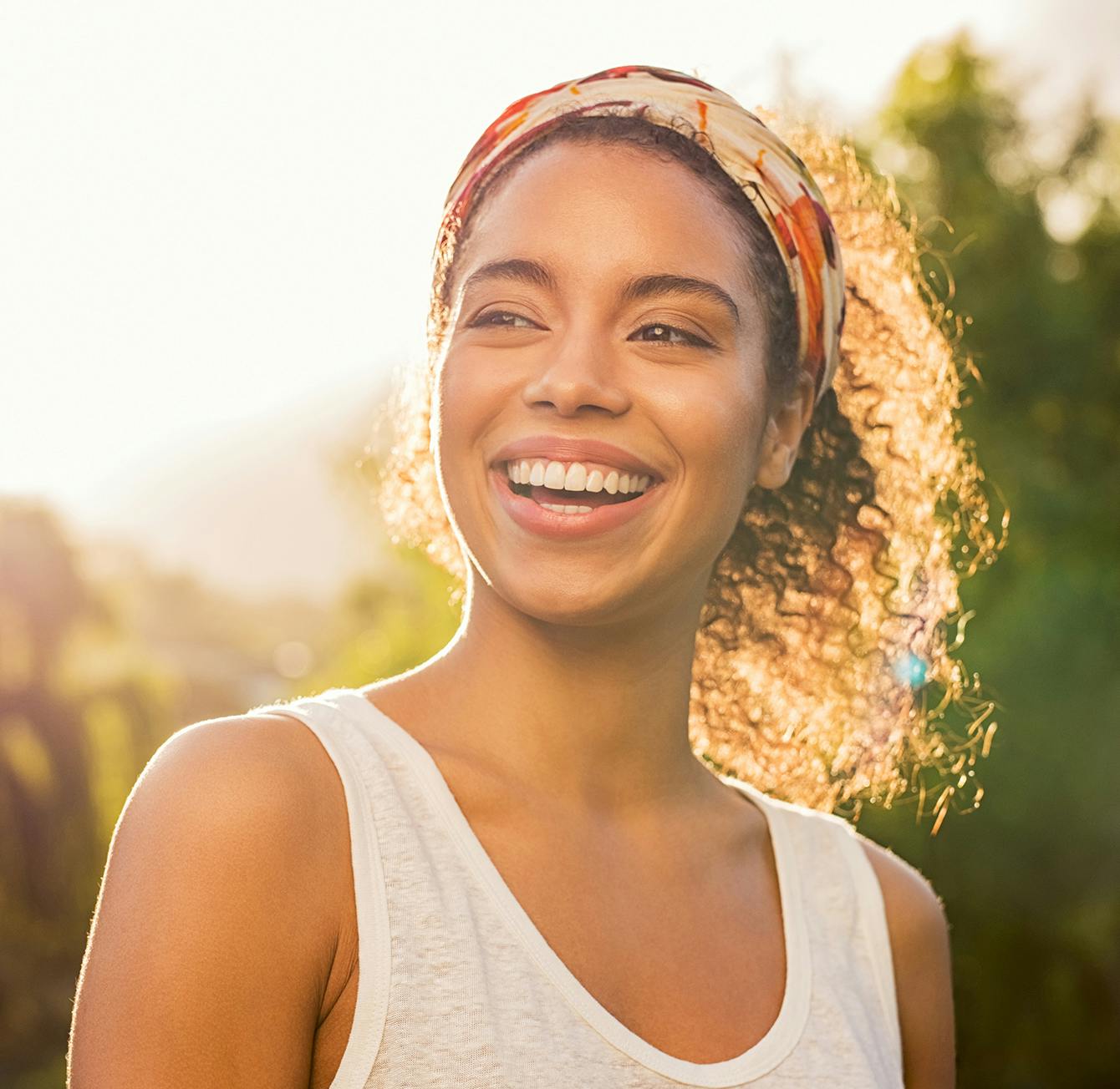 Woman smiling with the sun behind her