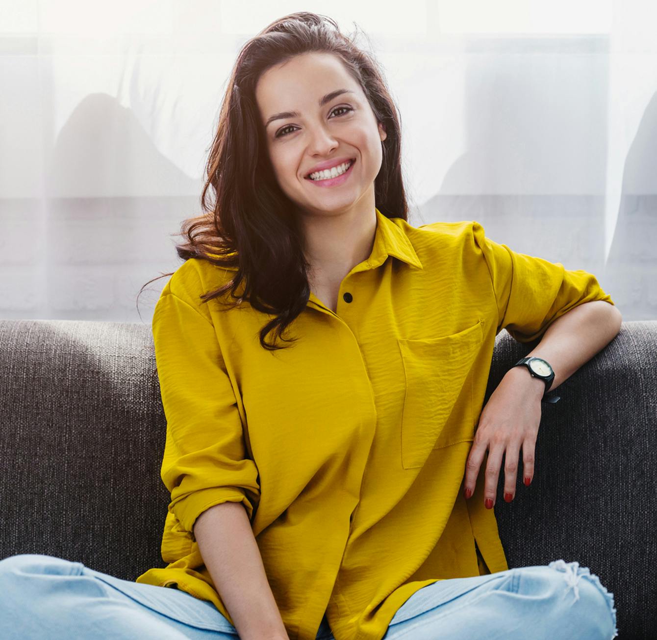 smiling woman sitting on couch