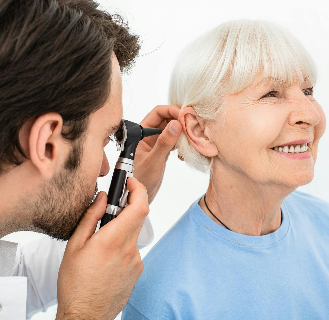 Male physician examing female patient's ear