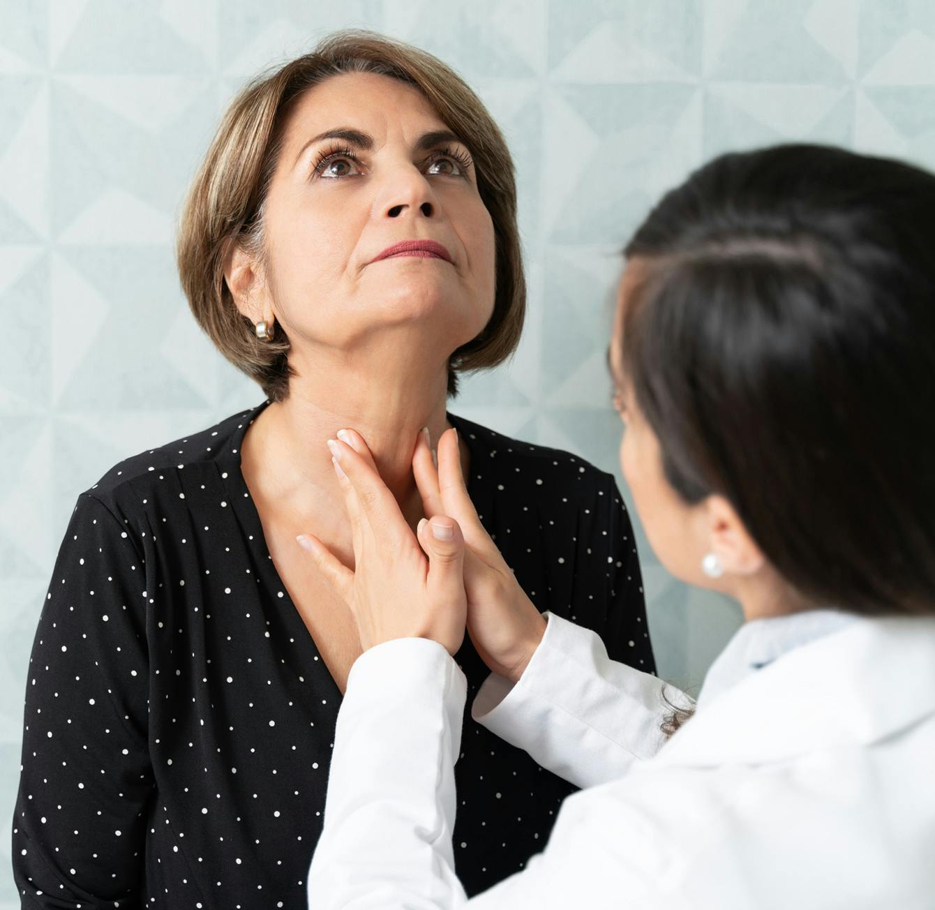 doctor touching patient neck