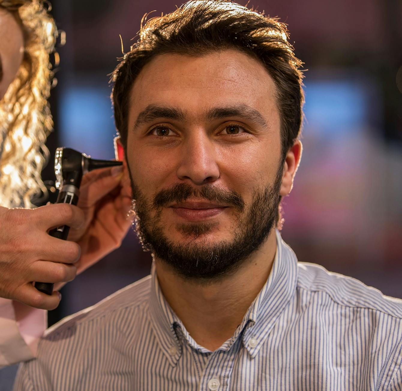 Doctor looking into a man's ear