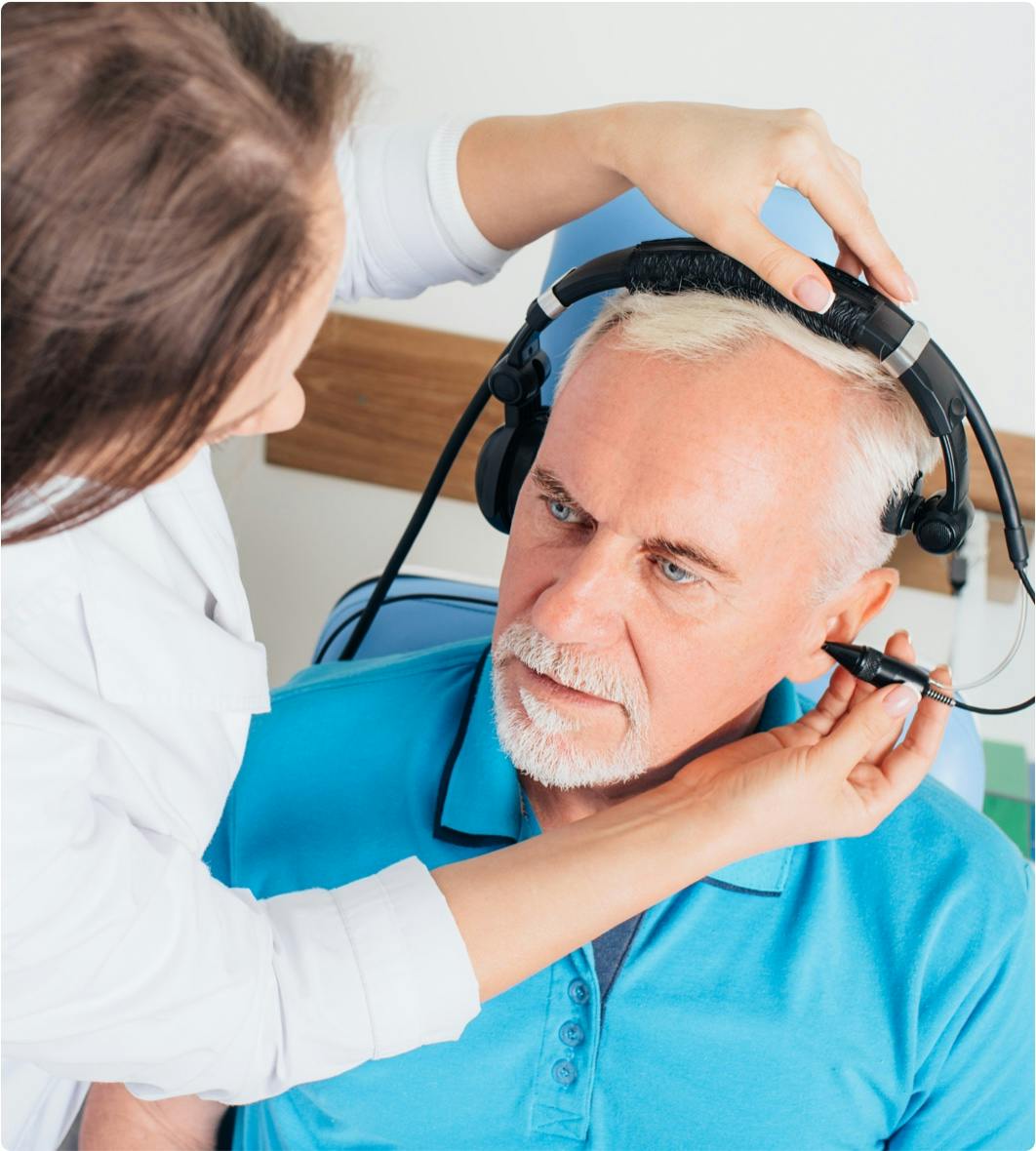 Physician treating a man's ears