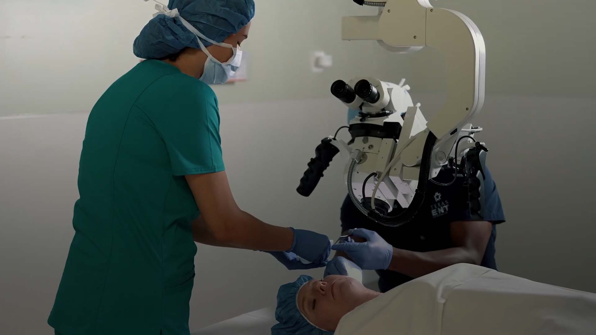 an image of a doctor and a nurse doing an ear procedure