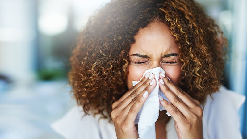 Woman blowing her nose