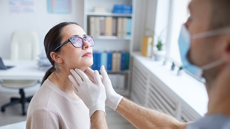 Physician examining patient's neck