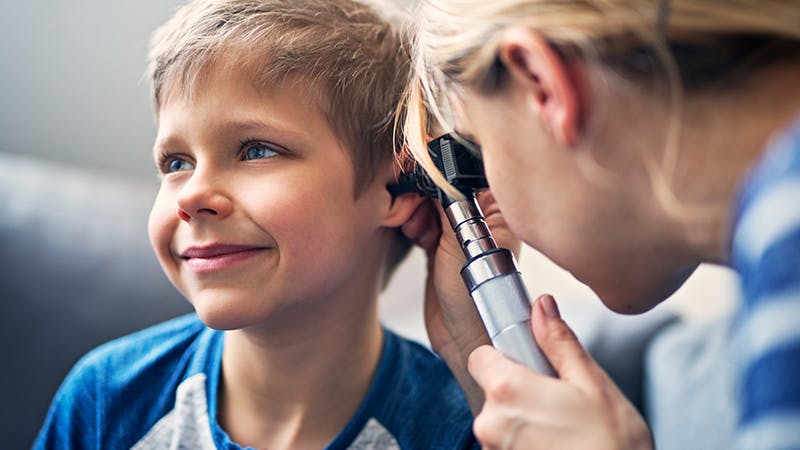 an image of a doctor doing an ear exam on a young child