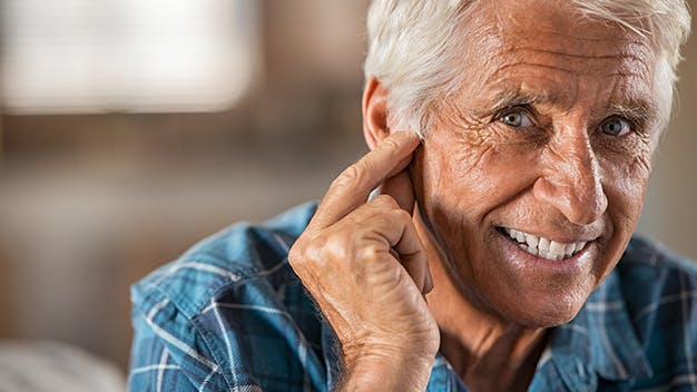 older man putting their hands to their ear