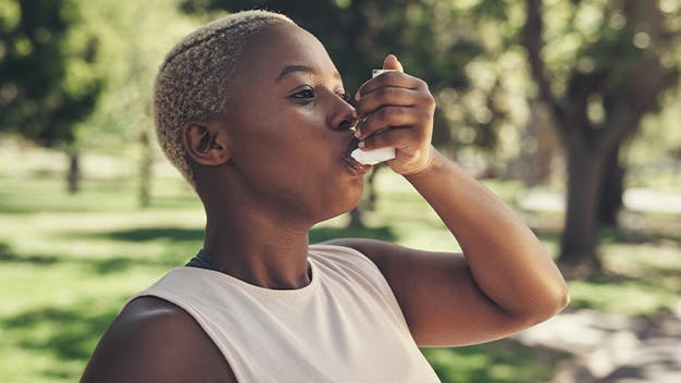 image of a woman using an inhaler