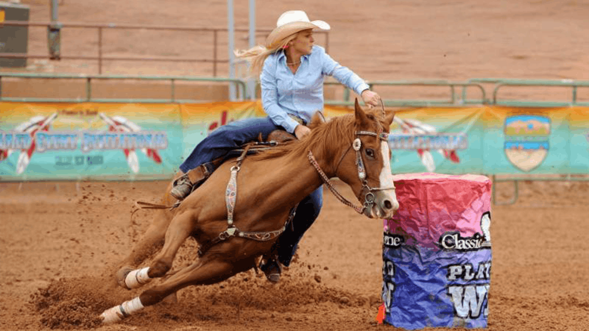 an image of a woman riding on a horse riding around a barrel