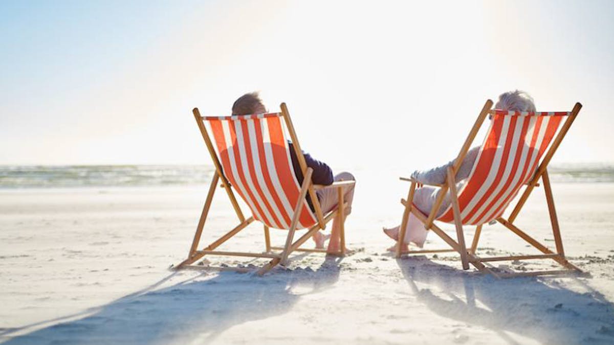 Two people sitting in beach chairs