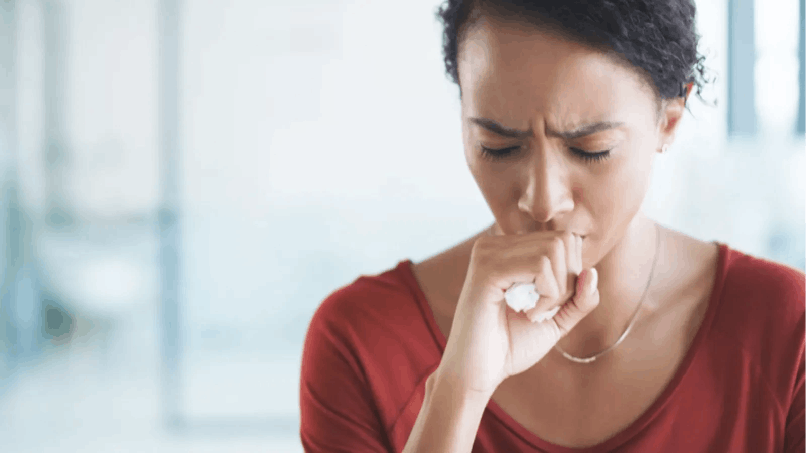 Woman coughing into her hand