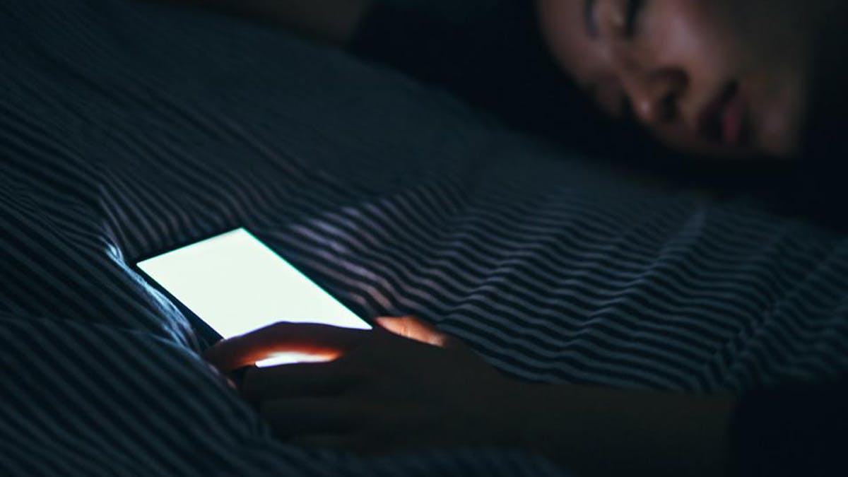an image of a woman falling asleep with her phone beside her