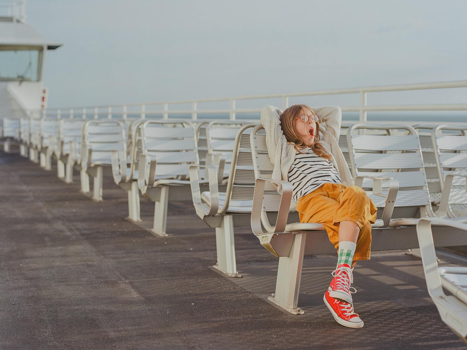 an image of a young girl yawning on the top of a boat