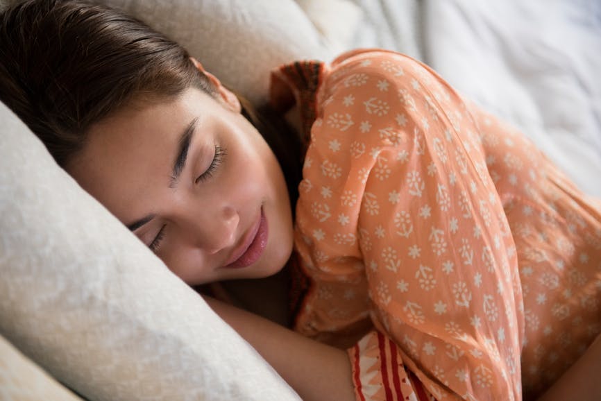 a woman sleeping in a peach colored shirt