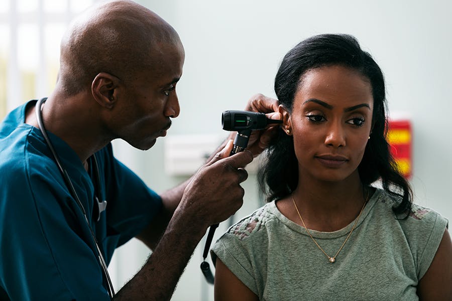 Doctor looking into a woman's ear