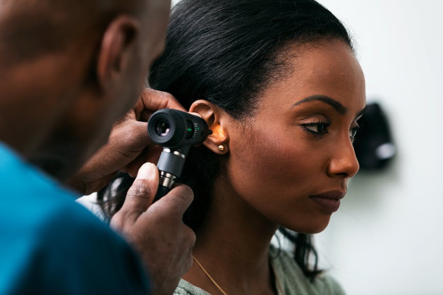 Doctor looking into a woman's ear