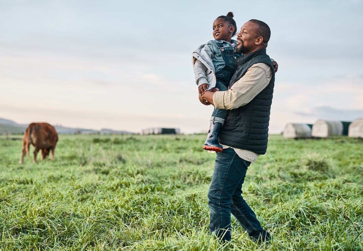 Man holding daughter in a field