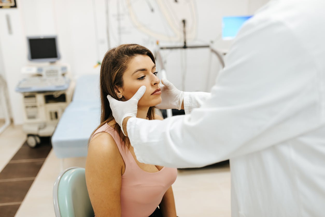 Doctor inspecting a woman's face