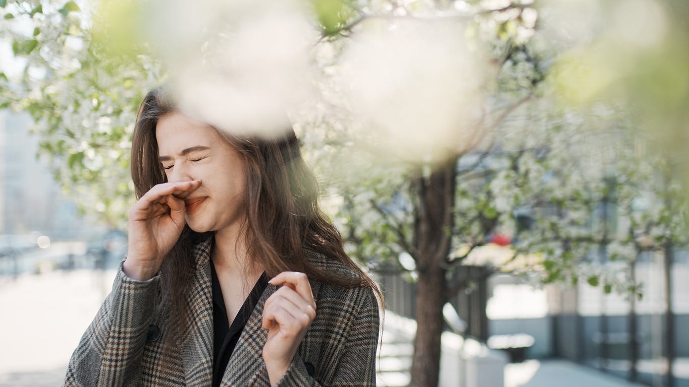 Woman outside dealing with seasonal allergies