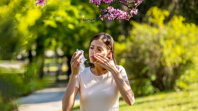 an image of a woman outside with allergies