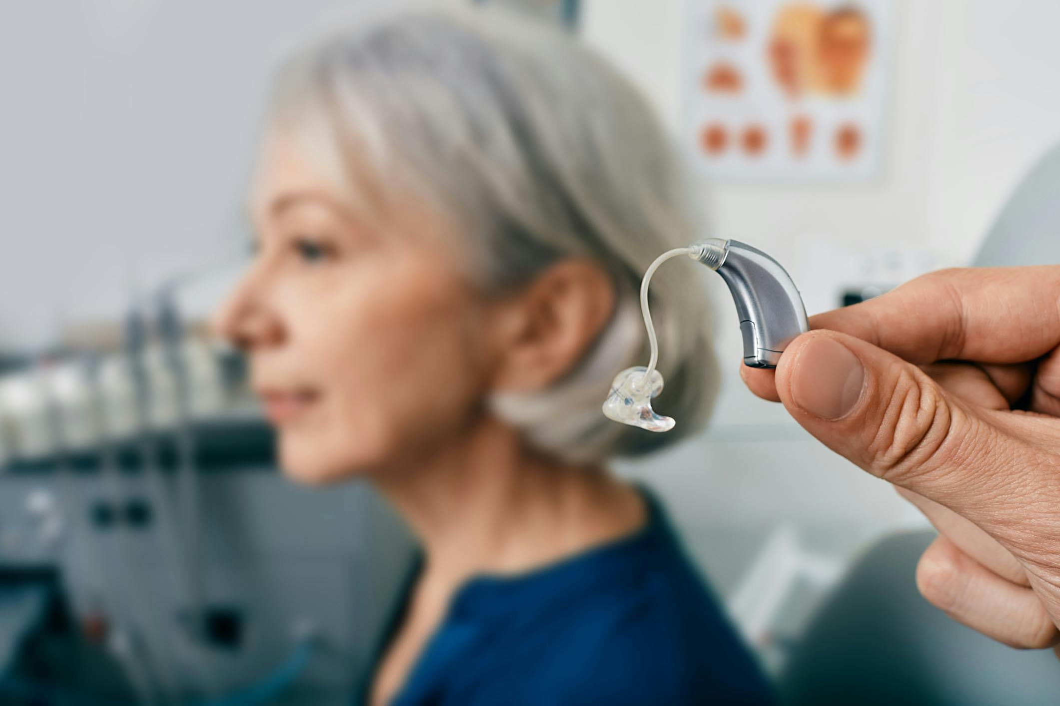 hearing aid being held up next to a woman