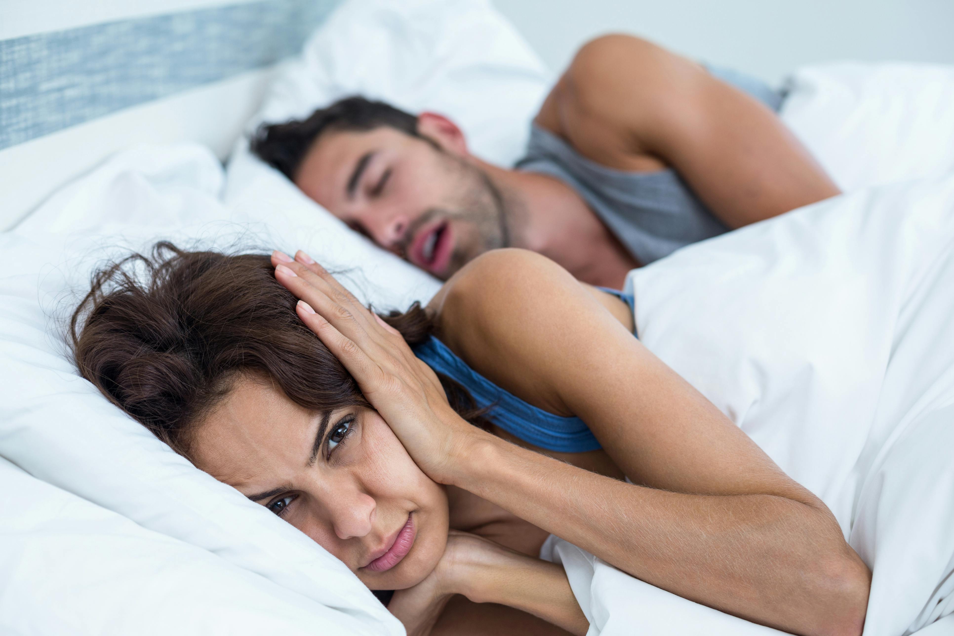 woman next to snoring man