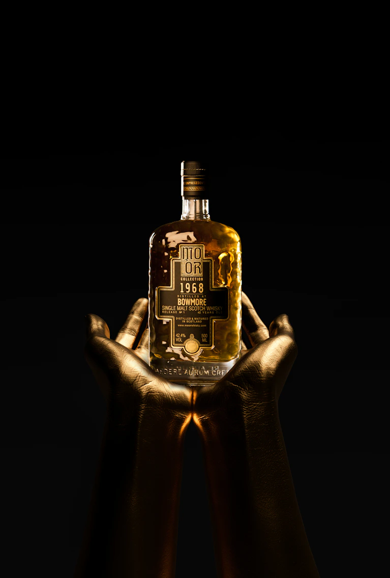 Gouden handen die een fles van de super zeldzame Bowmore 1968 Single Malt Scotch Whisky uit de exclusieve MO ÒR Collection vasthouden tegen een zwarte achtergrond.