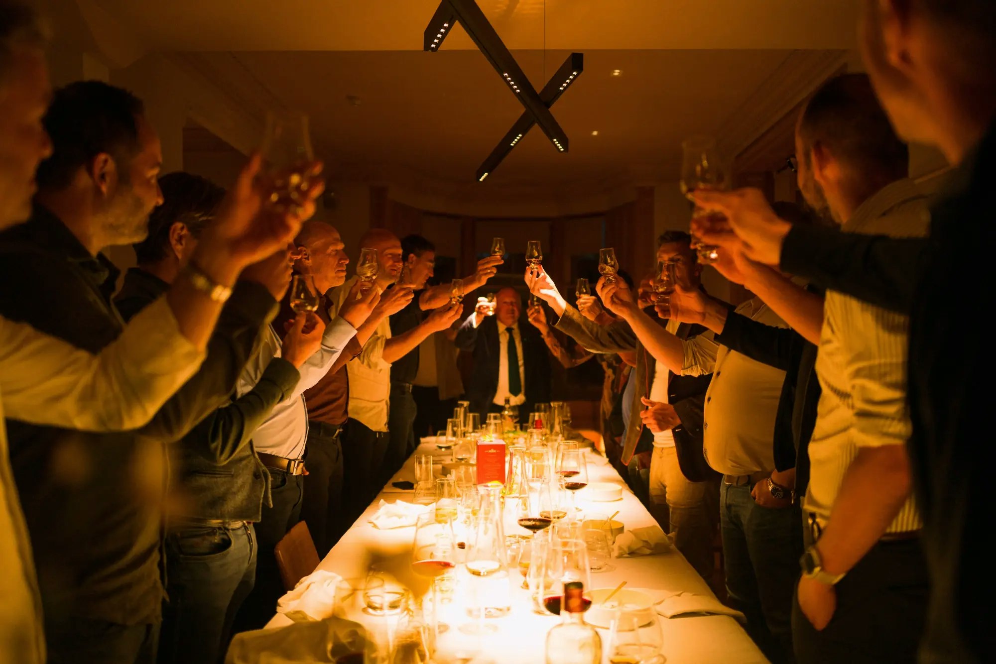 Members raising glasses at a tasting dinner