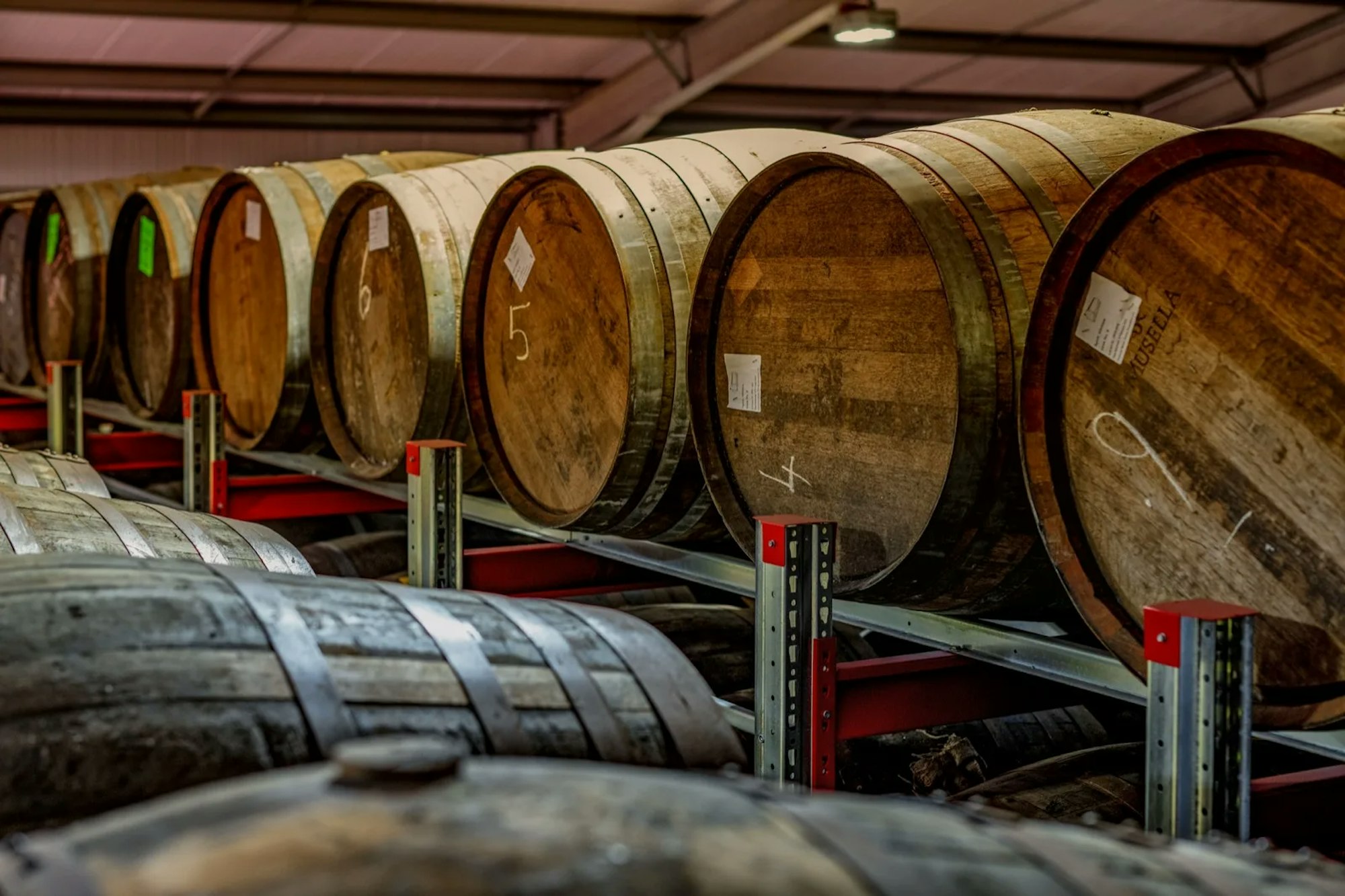 Genummerde whiskyvaten op stellingen in een warehouse