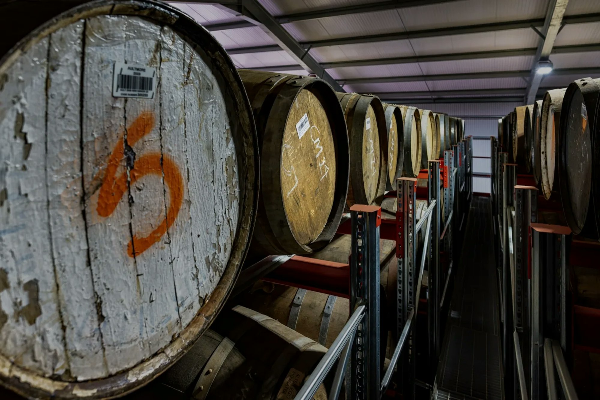 A marked whisky cask among rows of racked casks