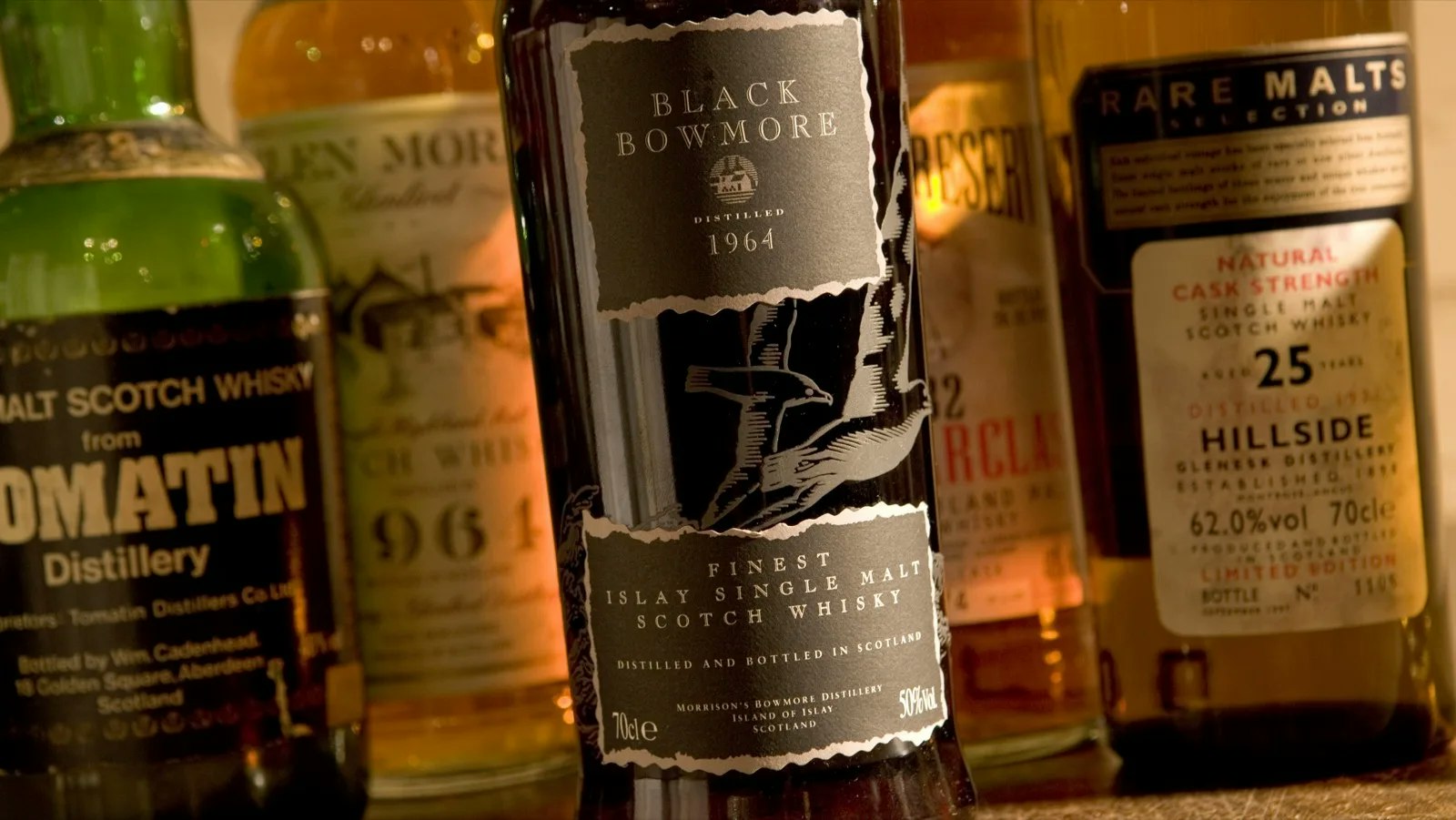 Close-up of a Black Bowmore 1964 bottle among other rare bottles