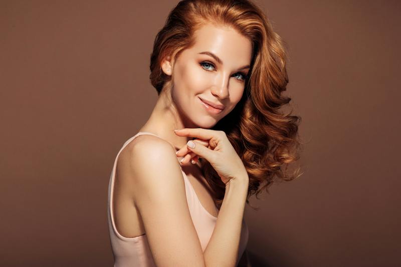Woman with beautiful skin smiling at camera in studio shoot