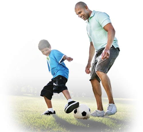 Man and child playing soccer