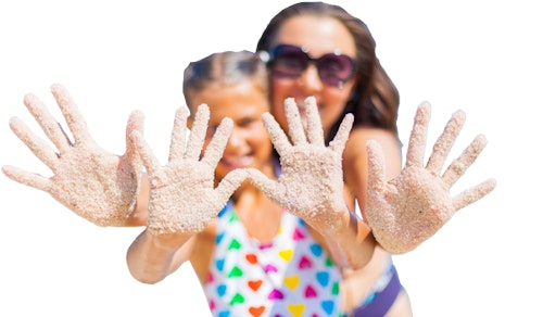 A young girl and older woman stand giving the camera a high five